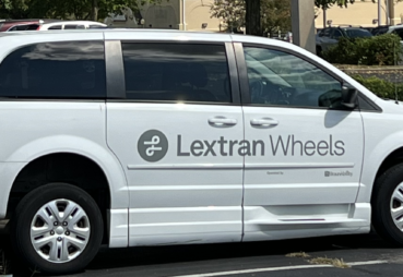 Image of a white paratransit van parked in a parking lot with the 